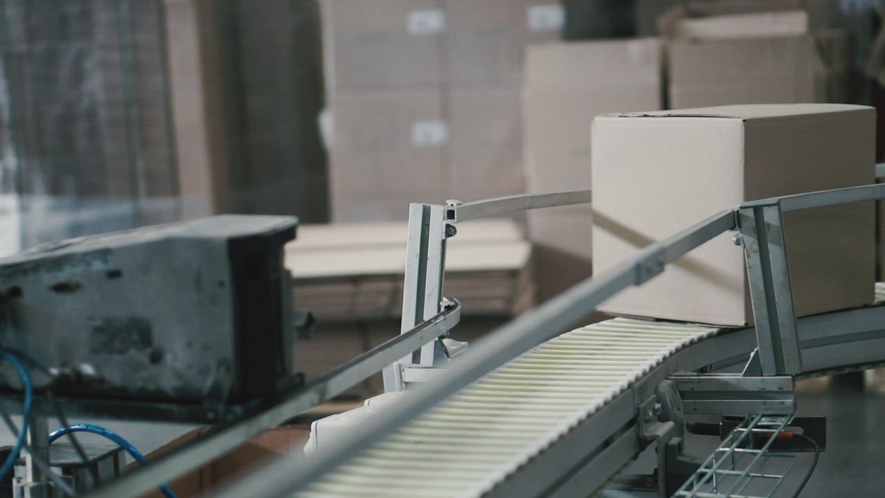A cardboard parcel moving along a conveyor belt in a warehouse