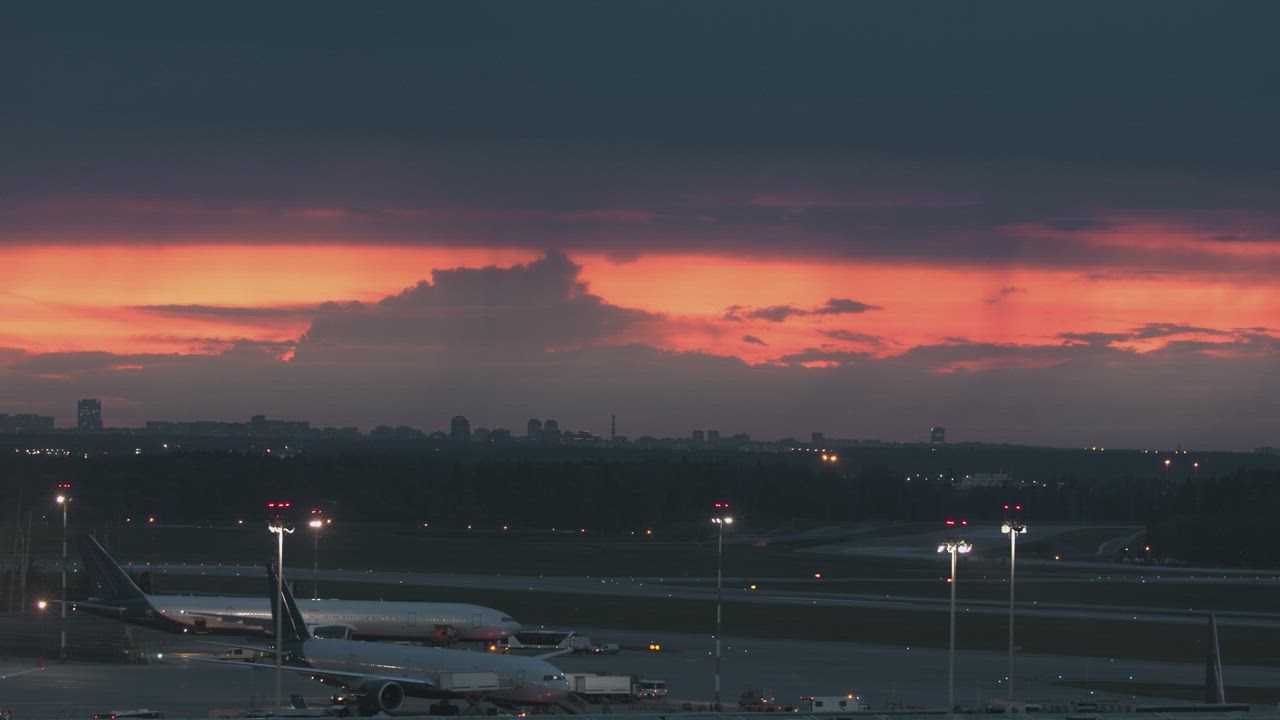 Wide-body aircraft parked on an airport apron under a dusk sky