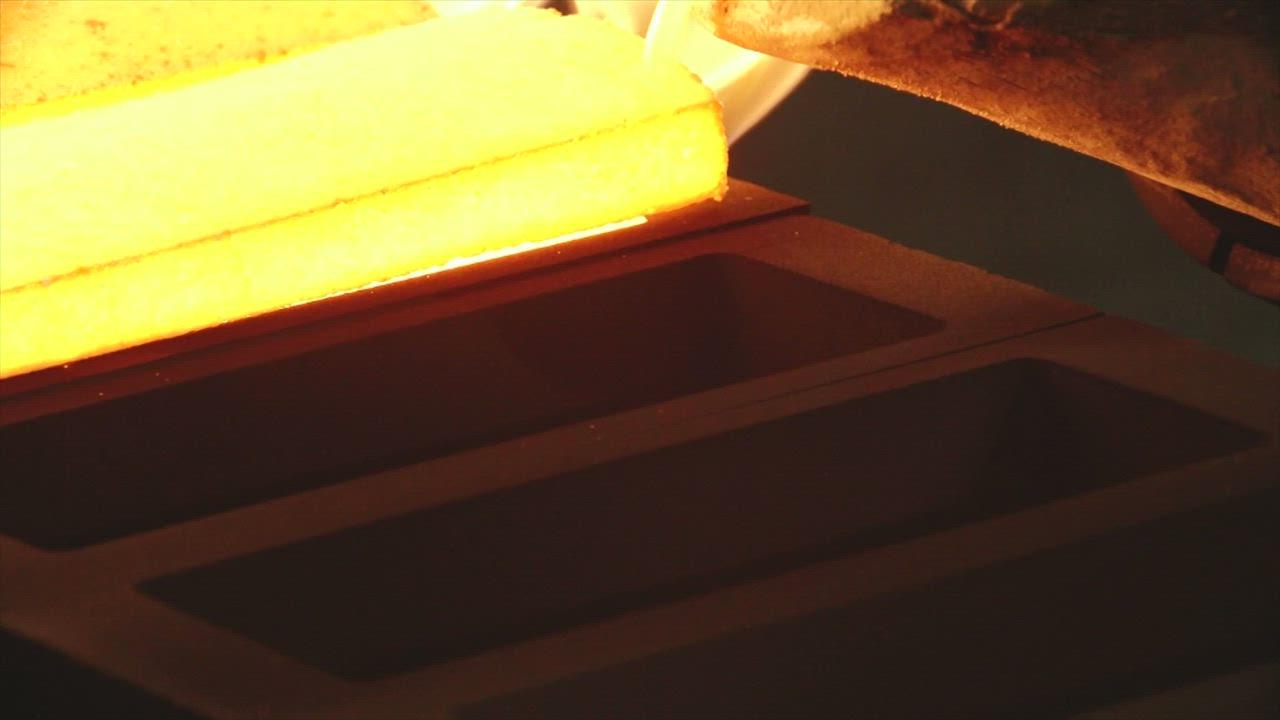 Molten gold being poured into a bullion bar mold